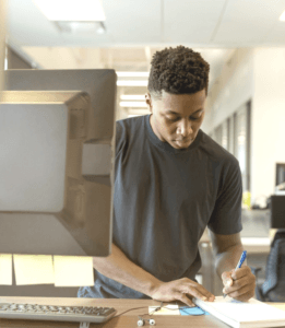 Member of talent community writing at a desk